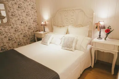 a bedroom with a large white bed with two tables at Apartamentos Aurelia Antica in Santiago de Compostela