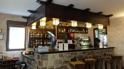 a bar in a restaurant with a stone wall at Hotel Rural La Casa del Peregrino in El Acebo de San Miguel