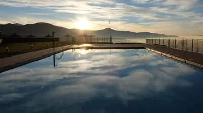 a swimming pool with the sun in the sky at Hotel Rural La Casa del Peregrino in El Acebo de San Miguel