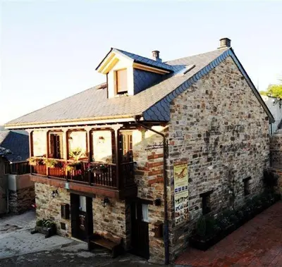 a brick building with a balcony on top of it at Hotel Rural La Casa del Peregrino in El Acebo de San Miguel