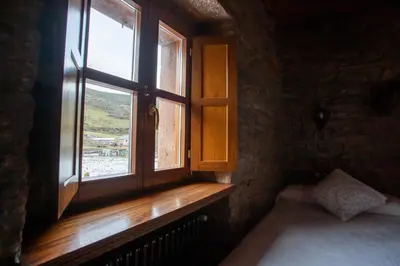 a bedroom with a window with a bed and a radiator at Casa Rural Anita in Cabrillanes
