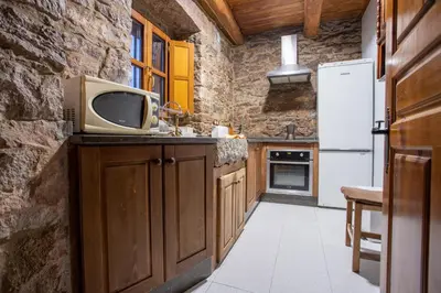a kitchen with a refrigerator and a tv on a counter at Casa Rural Anita in Cabrillanes