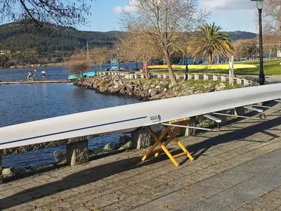 a long white surfboard sitting next to a body of water at CASA DO AVÒ in Castrelo de Miño