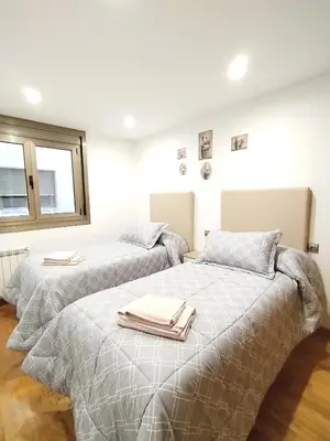 two beds with towels on top of them in a bedroom at Viveiro Bahía in Viveiro