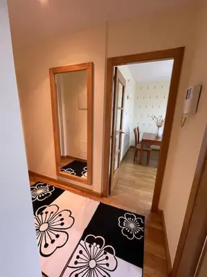 a hallway with a mirror and a rug on the floor at Apartamento Lugo Ciudad in Lugo