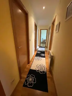 a hallway with black and white tiles on the floor at Apartamento Lugo Ciudad in Lugo