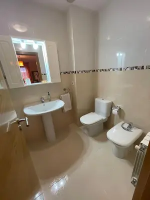 a bathroom with a sink and a toilet and a mirror at Apartamento Lugo Ciudad in Lugo