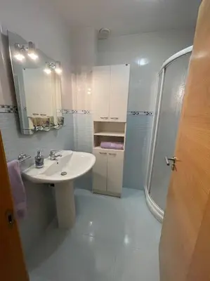 a white bathroom with a sink and a shower at Apartamento Lugo Ciudad in Lugo
