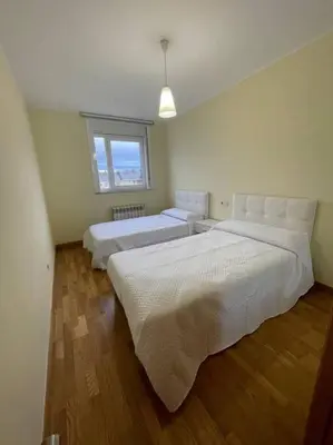 a bedroom with two beds and a window at Apartamento Lugo Ciudad in Lugo