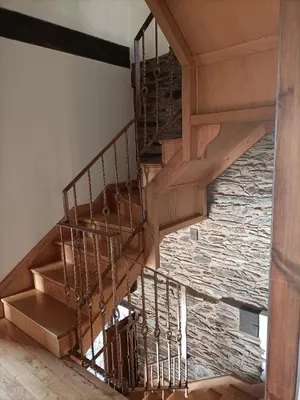 a spiral staircase in a house with a stone wall at CASA DA RIBEIRA in Quiroga