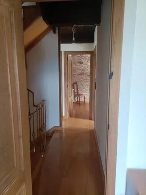 a hallway with a staircase and a chair in a room at CASA DA RIBEIRA in Quiroga