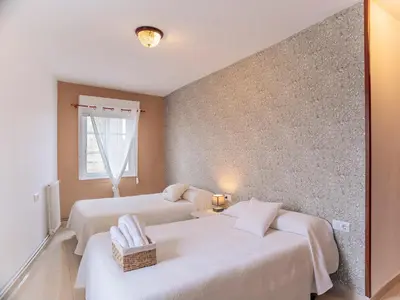 a bedroom with two beds and a wall at Hospedaje Ramos in Santiago de Compostela