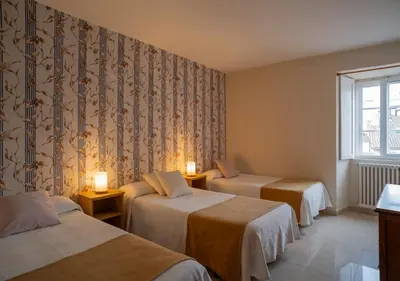 a hotel room with two beds and a window at Hospedaje Ramos in Santiago de Compostela