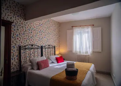 a bedroom with a bed and a wall with patterns at Hospedaje Ramos in Santiago de Compostela