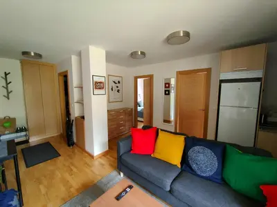 a living room with a couch with colorful pillows at Ventana al Paraíso del Oso - Somiedo. Window to Bear Paradise - Somiedo in Pola de Somiedo