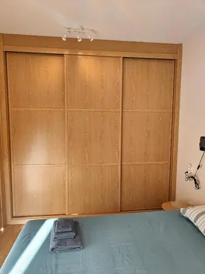 a bedroom with wooden cabinets and a bed at Ventana al Paraíso del Oso - Somiedo. Window to Bear Paradise - Somiedo in Pola de Somiedo