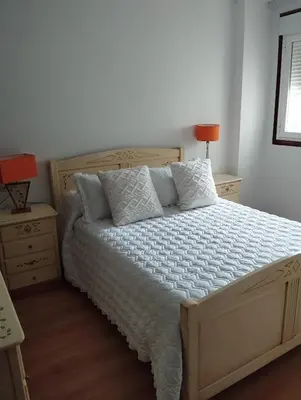 a bedroom with a large bed with white sheets and pillows at Jardines in O Barco de Valdeorras