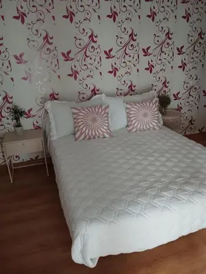a bedroom with a large white bed with pink pillows at Jardines in O Barco de Valdeorras