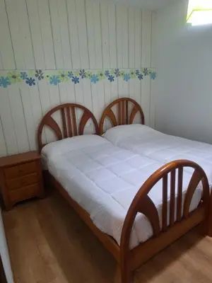 a bed in a room with a white mattress and a table at Jardines in O Barco de Valdeorras