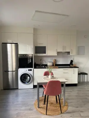 a kitchen with a table and chairs and a refrigerator at Apartamentos SARABIA LOFT in Ourense
