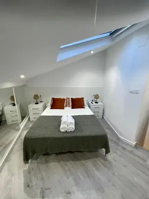 a bedroom with a bed with two towels on it at Apartamentos SARABIA DARRIBA in Ourense