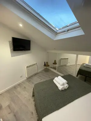 a bedroom with a skylight and a bed with towels on it at Apartamentos SARABIA DARRIBA in Ourense