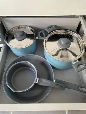 four pots and pans sitting in a drawer at Apartamentos SARABIA DARRIBA in Ourense