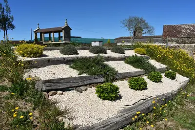 a garden with rocks and plants in front of a building at Cabanas do Carpinteiro / Santiago de Compostela - Rías Baixas in Pontevedra
