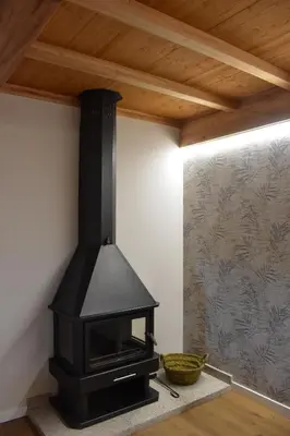 a fireplace in a room with a wooden ceiling at Cabanas do Carpinteiro / Santiago de Compostela - Rías Baixas in Pontevedra