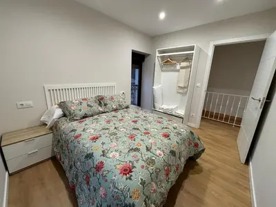 a bedroom with a bed with a floral bedspread at Cabanas do Carpinteiro / Santiago de Compostela - Rías Baixas in Pontevedra
