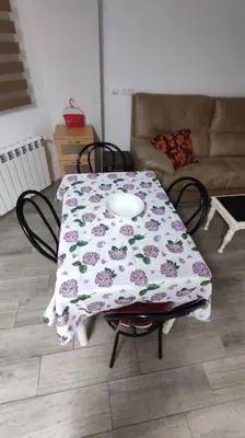 a table with a flowered table cloth on it in a living room at Piso Turístico Avda del Castillo in Ponferrada