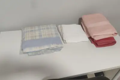 a table with several blankets and pillows on it at Piso Turístico Avda del Castillo in Ponferrada