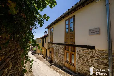 a stone building with wooden doors on a street at O Lar de Mateo in Monforte de Lemos