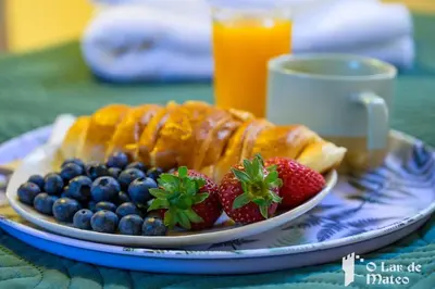 a plate of food with strawberries and blueberries on a table at O Lar de Mateo in Monforte de Lemos