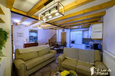 a living room with two couches and a kitchen at O Lar de Mateo in Monforte de Lemos