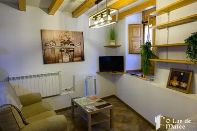 a living room with a couch a table and a tv at O Lar de Mateo in Monforte de Lemos