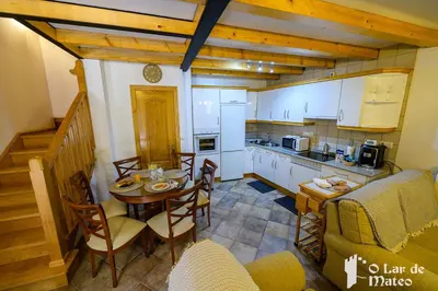a kitchen with a table and chairs in a room at O Lar de Mateo in Monforte de Lemos