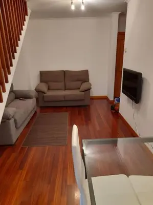 a living room with a couch and a television at Alojamiento entero cerca de Santiago de Compostela in A Coruña