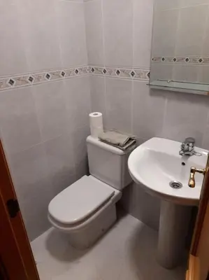 a white bathroom with a toilet and a sink at Alojamiento entero cerca de Santiago de Compostela in A Coruña