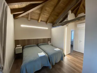 a bedroom with two beds and wooden ceilings at dpCristal Centro Histórico in Sarria