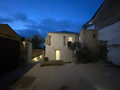 a white house at night with lights on at dpCristal Centro Histórico in Sarria