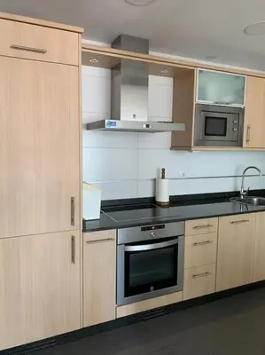 a kitchen with wooden cabinets and a stove top oven at Acogedor piso céntrico in Lugo
