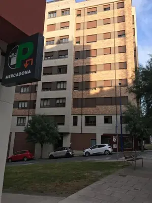 a large building with cars parked in front of it at Acogedor piso céntrico in Lugo