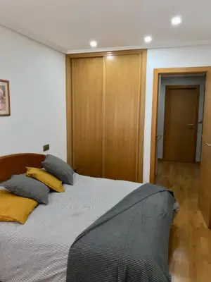 a bedroom with a large bed with yellow pillows at Acogedor piso céntrico in Lugo