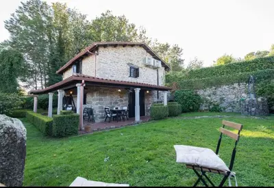 a stone house in a yard with a table and chairs at Casa con Piscina *Ribeira Sacra* in Ferreira de Panton