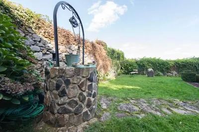 a stone wall with a fountain in a yard at Casa con Piscina *Ribeira Sacra* in Ferreira de Panton