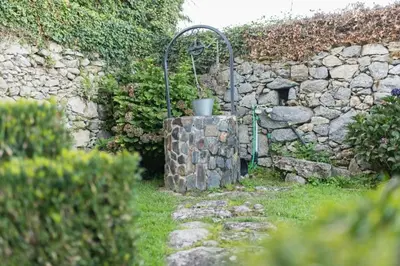 a stone wall with a fountain in a yard at Casa con Piscina *Ribeira Sacra* in Ferreira de Panton