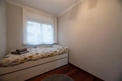a small bedroom with a bed and a window at Apartamento acogedor centrico in Monforte de Lemos