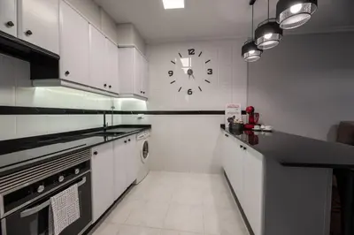 a large kitchen with a clock on the wall at Apartamento acogedor centrico in Monforte de Lemos