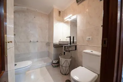 a bathroom with a white toilet and a sink at Apartamento acogedor centrico in Monforte de Lemos